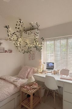 a bedroom with a bed, desk and computer on the table in front of it