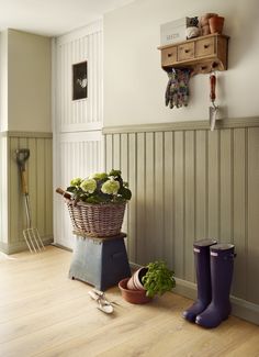 a basket filled with flowers sitting on top of a wooden floor next to gardening utensils