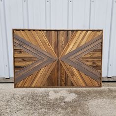 a large wooden door on the side of a building in front of a white wall