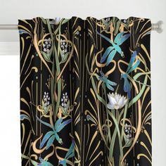 the curtains are decorated with flowers and plants on black fabric, hanging in front of a window