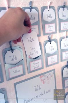 a person is pointing to some tags on a bulletin board that are attached to the wall