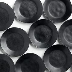 black plates are arranged in a pattern on a white surface