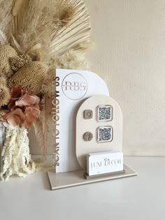 an assortment of decorative items displayed on a table with a vase and feather fan in the background