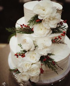 a wedding cake with white flowers and greenery