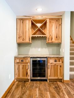 an empty kitchen with wooden cabinets and stairs