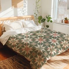 a bed in a room with a plant on the side and a window behind it