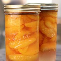 two jars filled with sliced oranges sitting on top of a table