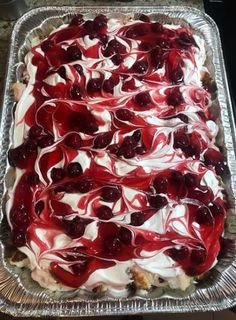 a cake covered in cherries and white frosting on top of a metal pan