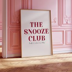 a poster on the floor in front of a pink wall that says the snooze club