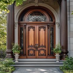 a large wooden door with two planters on the steps and an arch above it