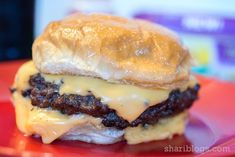 a cheeseburger is sitting on a red plate