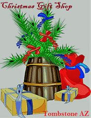 a christmas tree in a pot next to two wrapped presents and a red bag with blue ribbon