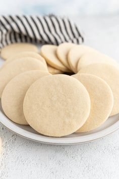 a white plate topped with cookies next to a black and white striped napkin on top of a table