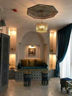 a living room filled with furniture and a chandelier hanging from the ceiling next to a window