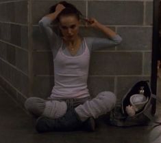 a young woman sitting on the floor with her hair combed