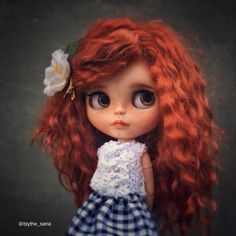 a doll with red hair wearing a blue and white dress