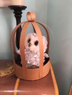 an owl in a paper bag sitting on top of a table