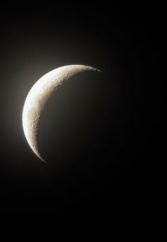 the moon is seen in the dark sky with its shadow on it's side