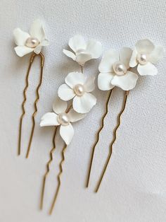 A set of 3 beautiful floral hairpins are made from white durable and light clay. Each flower's petal is handmade by me. Hand wired into small branches with non-tarnish gold wire. Each flower center is adorned with genuine freshwater pearls to add a touch of elegance and luxury. Perfect for your bohemian garden-inspired wedding. DETAILS - Ivory/white flowers (cold porcelain clay) - Non tarnish gold wire - Natural freshwater pearls - gold hair pin base x 3 Due to the handmade nature of each access Cold Porcelain Jewelry, Flower Hair Pins Wedding, Wedding Flower Hair, Gold Bracelet Wedding, Bridal Flower Headband, Flower Hair Pins, Bohemian Garden, Light Clay, Gold Hair Pin