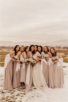 a group of women standing next to each other on top of a snow covered field