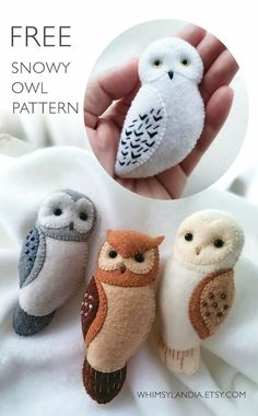 three small stuffed owls sitting on top of a white cloth covered bed next to a person's hand