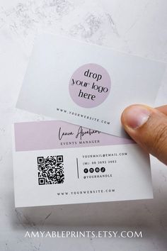 someone holding up two business cards with the word drop your logo here written on them