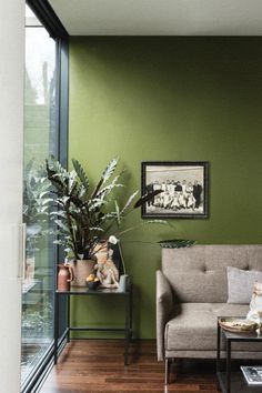 a living room with green walls and wooden floors