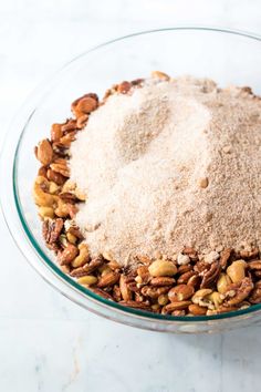 a glass bowl filled with nuts on top of a table