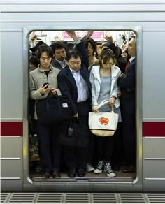 a group of people standing next to each other on a train