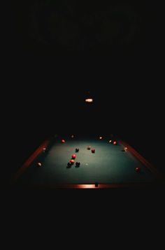 a pool table in the dark with balls on it