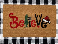 a door mat with the word believe on it and santa hat in black and white checkered fabric