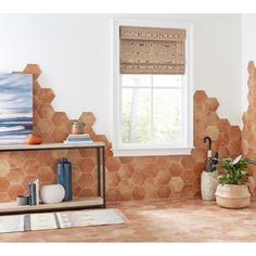 a tiled bathroom with an open window and potted plants on the shelf next to it