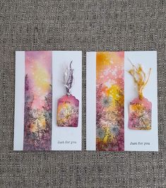 three cards with different designs on them sitting on a cloth covered surface, one has a tag and the other has an image of flowers