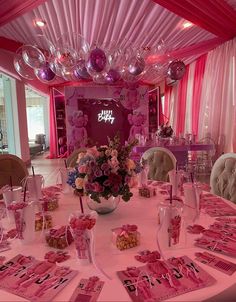 a table set up for a party with pink decorations