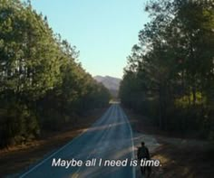 a man standing on the side of a road in front of trees with a quote about maybe all i need is time