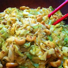 a bowl filled with noodles and vegetables next to chopsticks