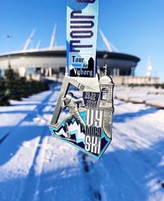 a medal hanging from the side of a building in the snow with an olympic logo on it