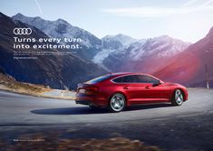 a red car driving down a road next to mountains