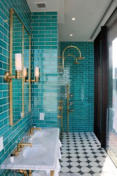 a bathroom with blue tiles and gold fixtures