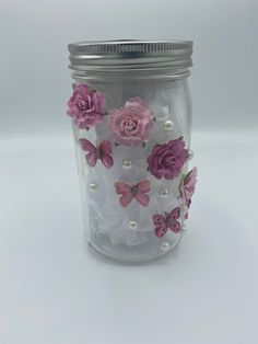 a glass jar filled with pink flowers and pearls