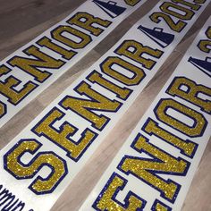 three yellow and blue sequined letters are on the floor next to each other