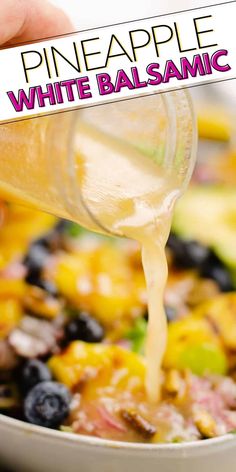 a person pouring dressing into a bowl full of fruit and vegetables with the words pineapple white balsamc