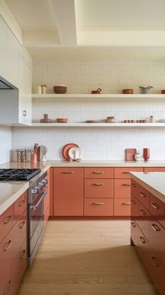 Discover a modern kitchen featuring terracotta cabinetry, a white backsplash, and light wood floors for a cozy yet chic vibe. Perfect for a stylish home! Tags: #TerracottaWhiteCombo #KitchenIdeas2024 #ModernRustic #InteriorGoals #WarmDesign Terracotta And White Kitchen, Terrazo Kitchen Counters, Terracotta Kitchen Ideas, Terra Cotta Kitchen Cabinets, Terracotta Cabinets, Terracotta Kitchen Cabinets, Terracotta Backsplash Kitchen, Terra Cotta Backsplash, Terra Cotta Kitchen