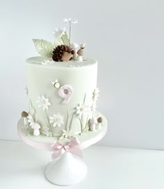 a white cake decorated with flowers and leaves