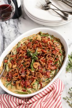 a casserole dish with spinach and bacon in it on a red and white striped napkin