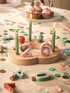 a table topped with candles and cupcakes on top of a table covered in confetti