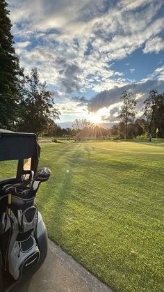 a golf bag sitting on the side of a road next to a green grass covered field