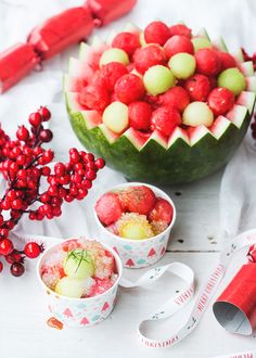 a table topped with lots of different types of fruit next to measuring tape and cupcakes