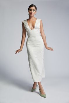 a woman in a white dress posing for the camera