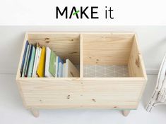 a wooden box filled with books on top of a white table next to a wicker chair